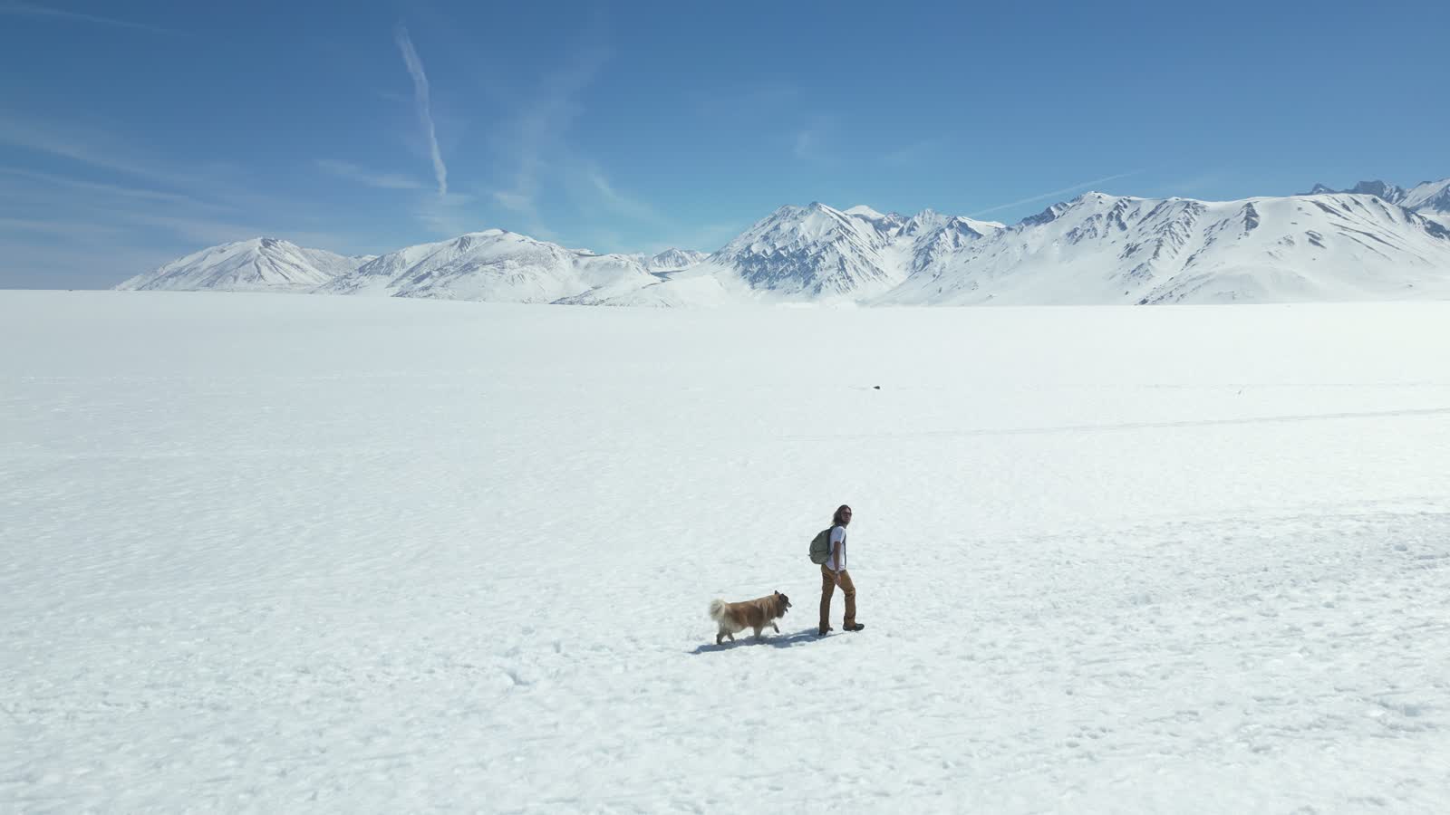 Walking across a frozen lake with Captain, the Sierra behind