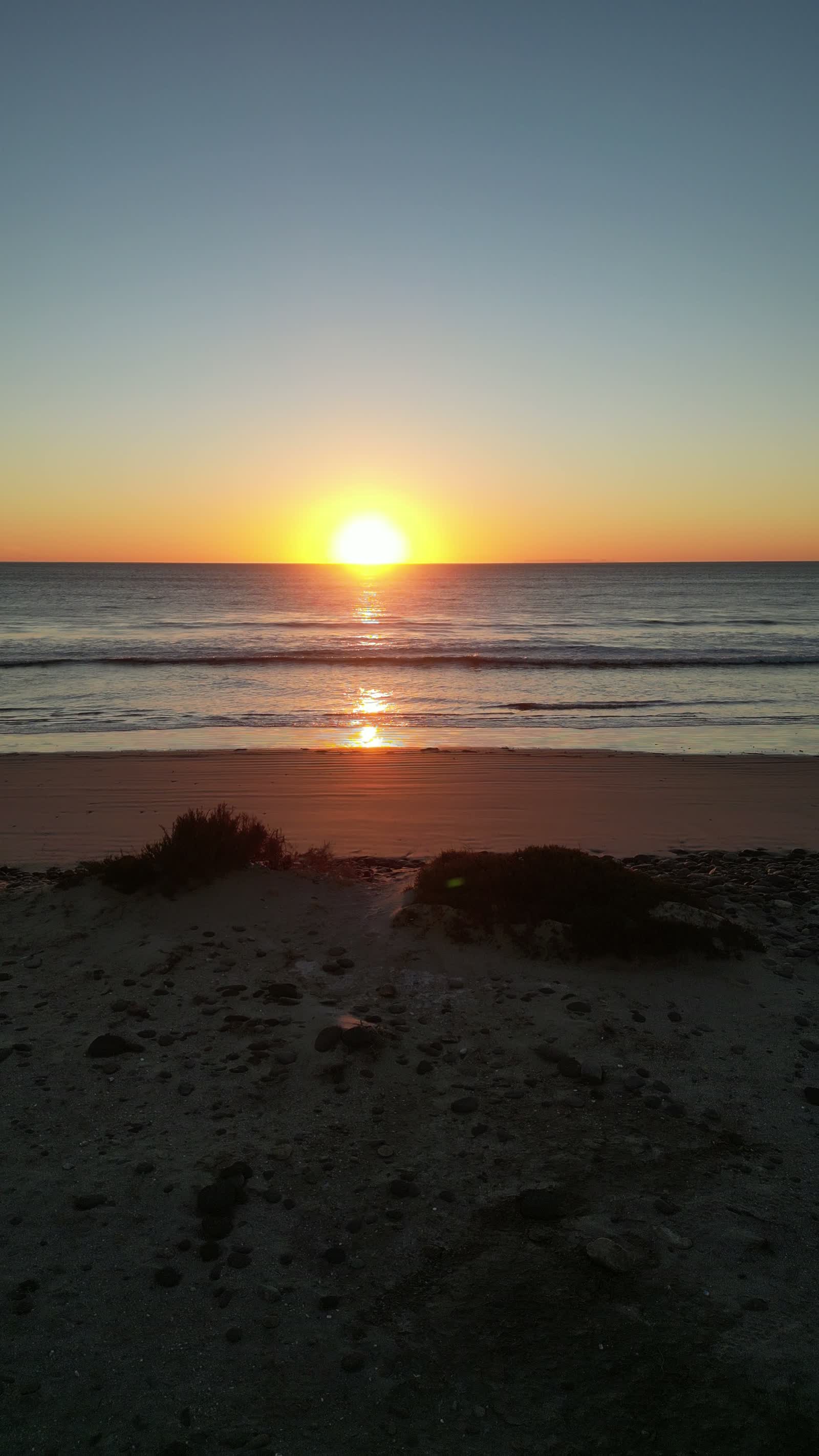 The sun setting over an ocean swell